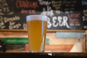 Close-up of a glass of light beer on a bar table, showcasing its crisp, refreshing appearance.