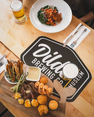 Tasty food and craft beer on a table inside Dildo Brewing Co. Taproom, ready to be enjoyed.