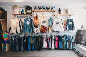 Interior of Dildo Brewing Co. Bottle Shop on Water Street, St. John's, featuring a wall with branded merchandise on hangers and shelves.