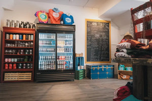 Interior of Dildo Brewing Co. Bottle Shop on Water Street, St. John's, showcasing branded merchandise on shelves, with a fridge stocked with fresh beer.